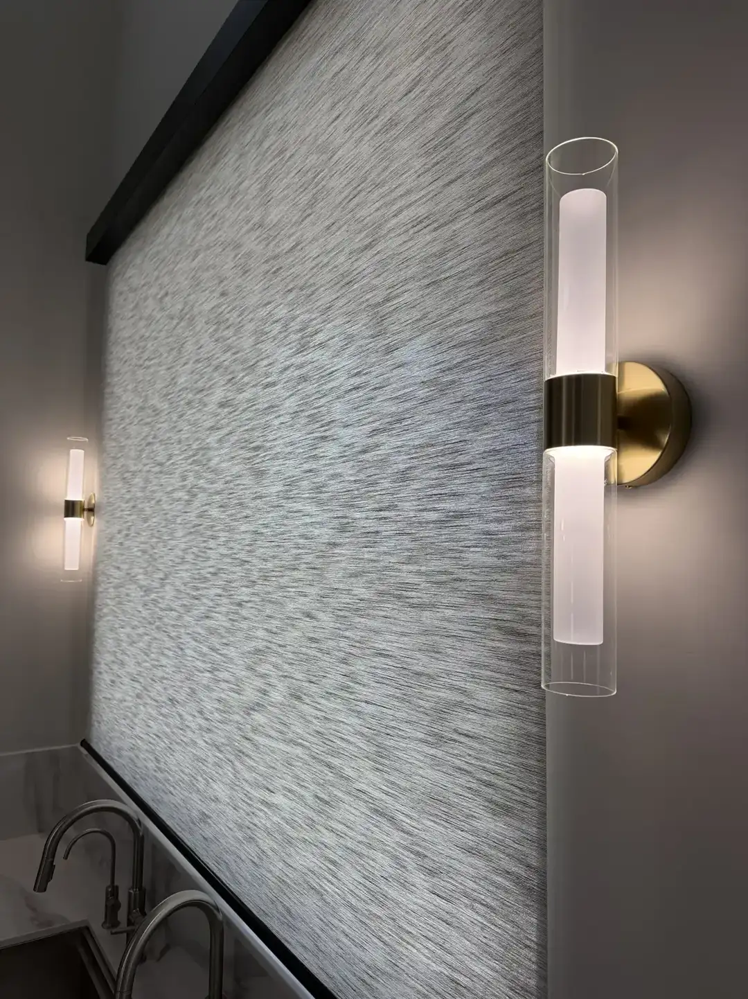 Brass cylinder sconces flanking a kitchen window wall