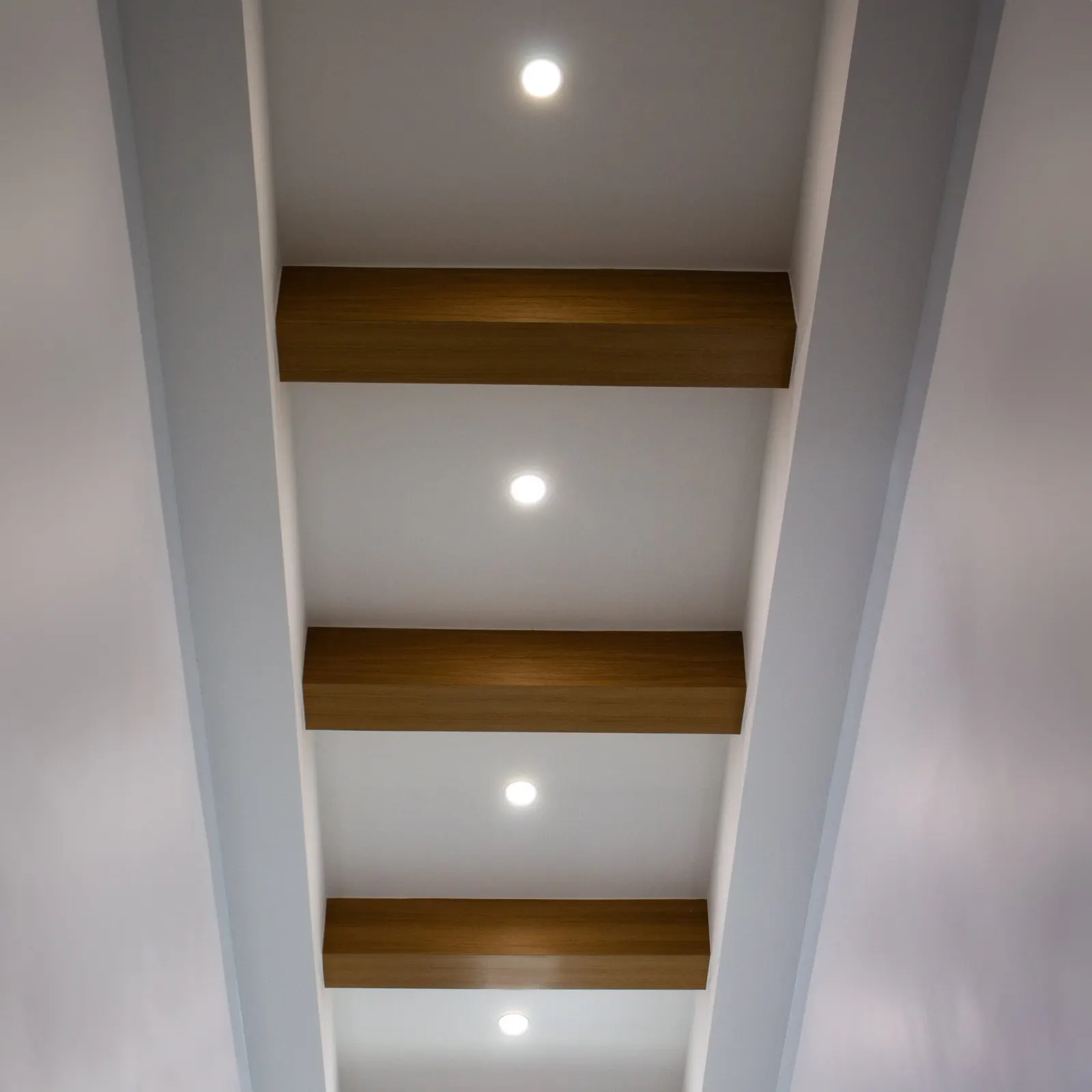 Recessed can lighting across a living space ceiling